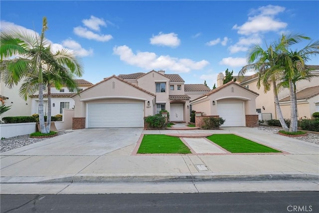 mediterranean / spanish house with a garage, concrete driveway, and stucco siding