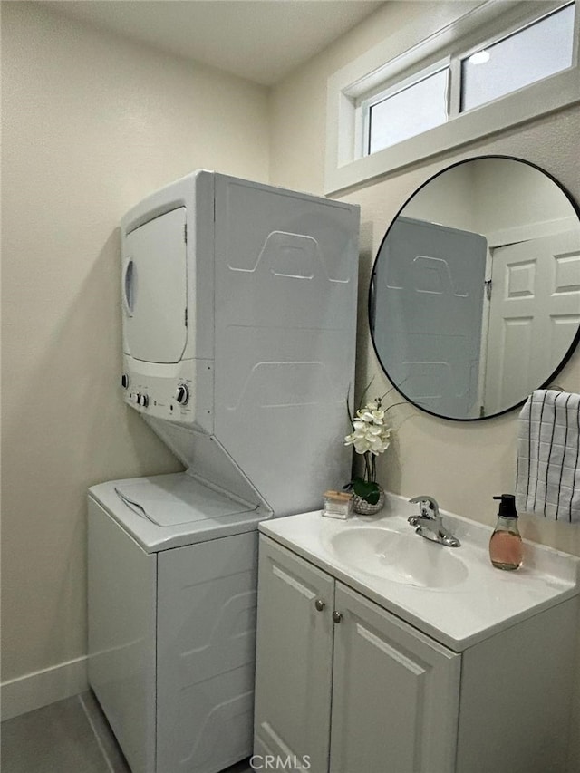 washroom with stacked washer and dryer and sink