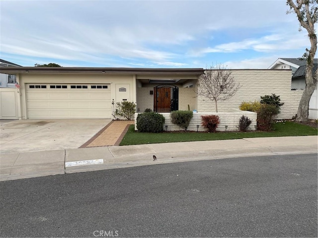 view of front of home with brick siding, concrete driveway, and an attached garage