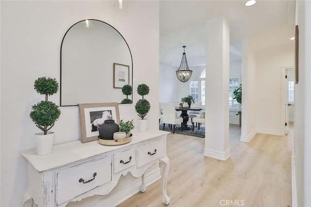 hall featuring a notable chandelier and light hardwood / wood-style floors