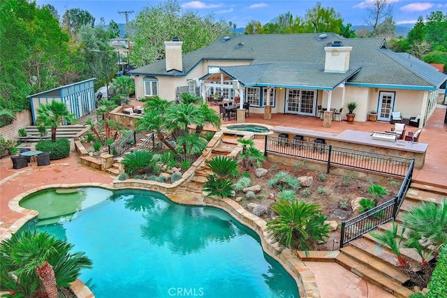 view of swimming pool featuring a patio and an in ground hot tub