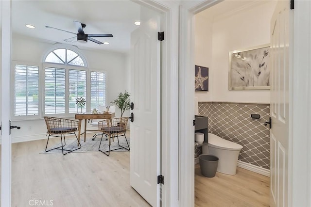 bathroom featuring ceiling fan, toilet, hardwood / wood-style floors, and tile walls