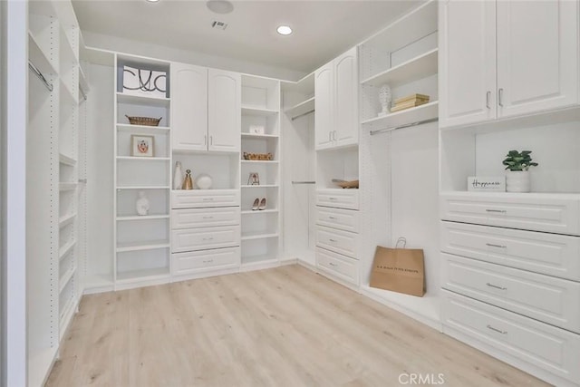 walk in closet with light hardwood / wood-style floors