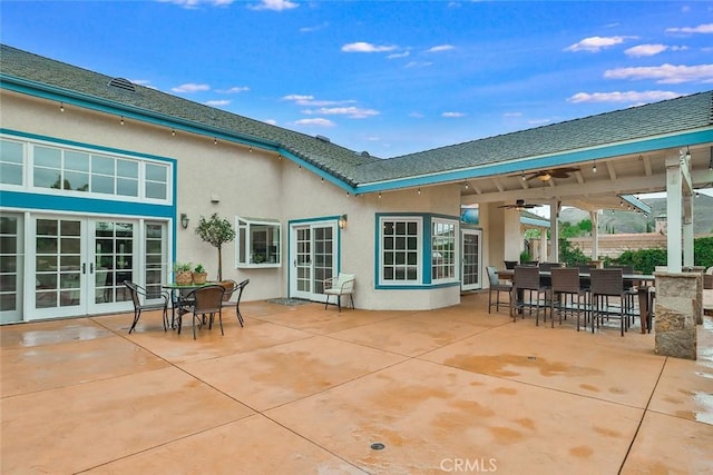 rear view of property featuring a patio, exterior bar, ceiling fan, and french doors