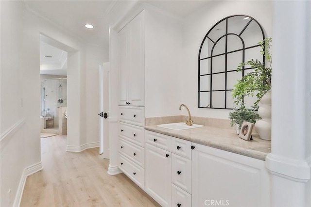 interior space with a shower with door, wood-type flooring, and vanity