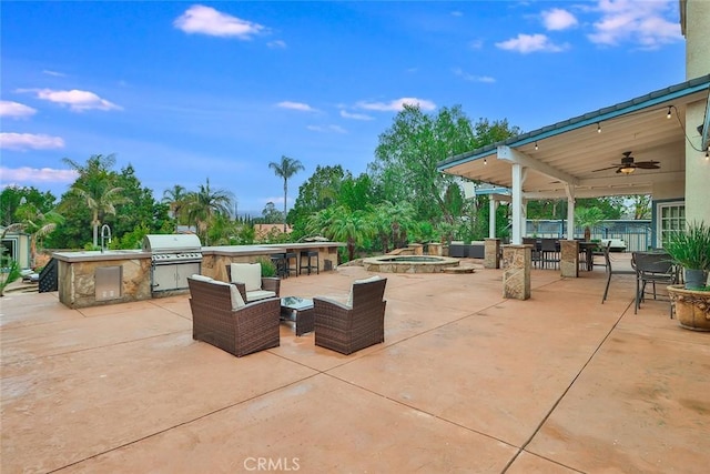 view of patio with area for grilling, a wet bar, an outdoor hangout area, grilling area, and ceiling fan