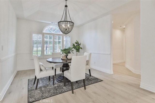 dining space with a notable chandelier and light hardwood / wood-style floors