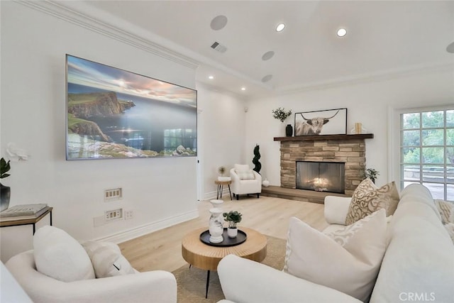 living room featuring crown molding, hardwood / wood-style flooring, and a fireplace