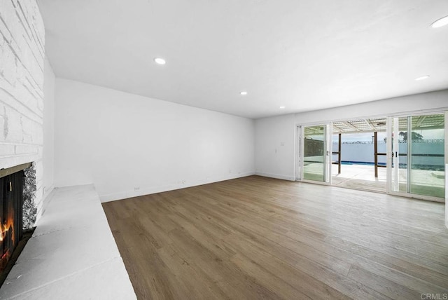 unfurnished living room with hardwood / wood-style flooring and a fireplace