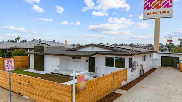 single story home featuring a garage and solar panels