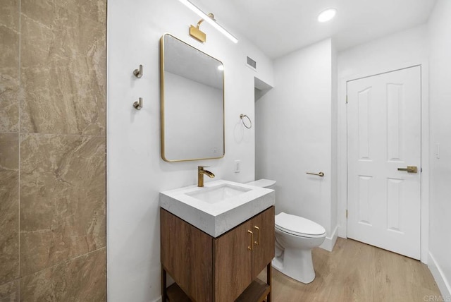 bathroom with vanity, toilet, and wood-type flooring