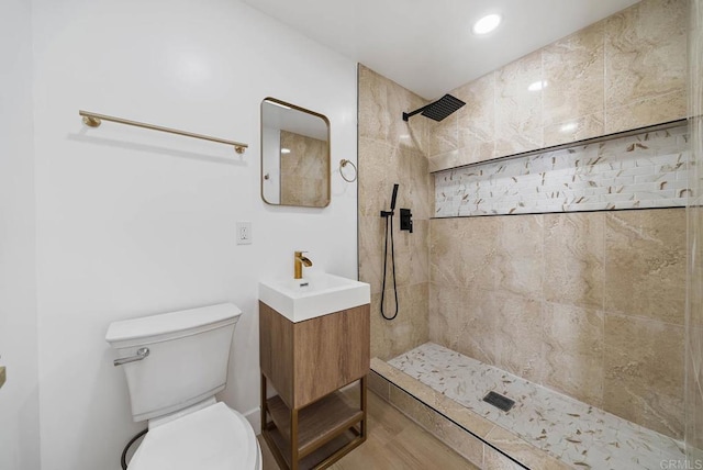 bathroom featuring tiled shower, sink, and toilet