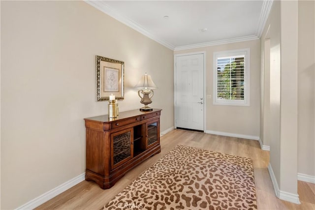 foyer entrance featuring ornamental molding, light wood-type flooring, and baseboards