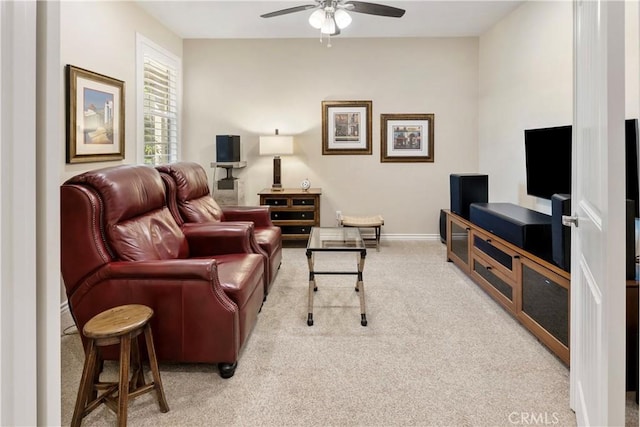 carpeted living area featuring ceiling fan and baseboards