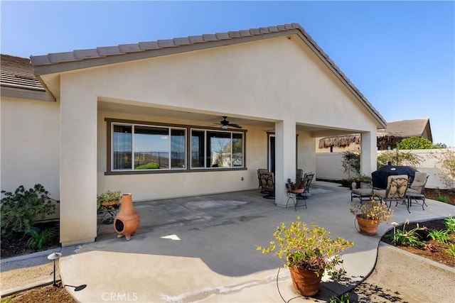 back of house featuring ceiling fan, a patio, fence, a tiled roof, and stucco siding