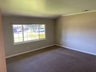 empty room featuring dark carpet