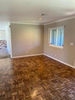 spare room featuring dark parquet flooring and ornamental molding