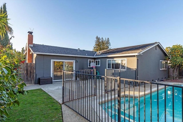 back of house with a fenced in pool and a patio area