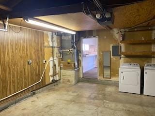 basement with wooden walls and washer and clothes dryer