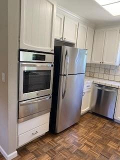 kitchen featuring tasteful backsplash, dark parquet flooring, appliances with stainless steel finishes, and white cabinets