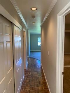 hallway with crown molding and dark parquet floors