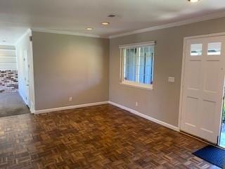 entryway featuring dark parquet flooring and ornamental molding