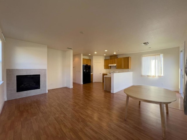 unfurnished living room featuring a fireplace and dark hardwood / wood-style floors