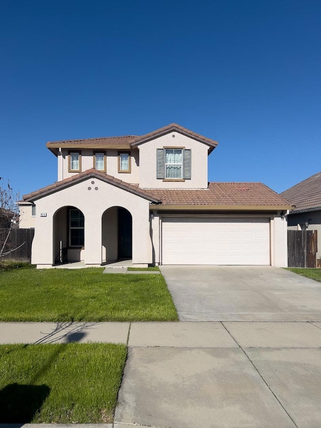 mediterranean / spanish house featuring a garage and a front lawn