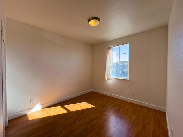 spare room with dark wood-type flooring