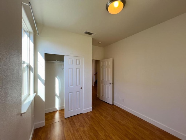 unfurnished bedroom with hardwood / wood-style flooring and a closet