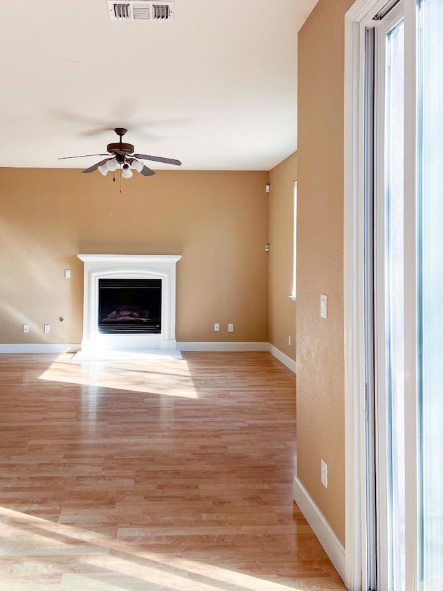 unfurnished living room featuring ceiling fan and light hardwood / wood-style floors