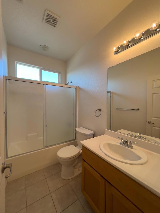 full bathroom featuring toilet, vanity, bath / shower combo with glass door, and tile patterned flooring