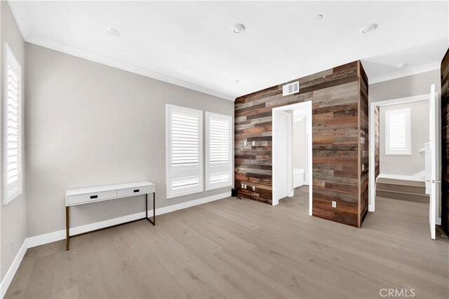 249 Chorus, Irvine, CA 92618 - unfurnished bedroom with wood finished floors, an accent wall, crown molding, wooden walls, and baseboards