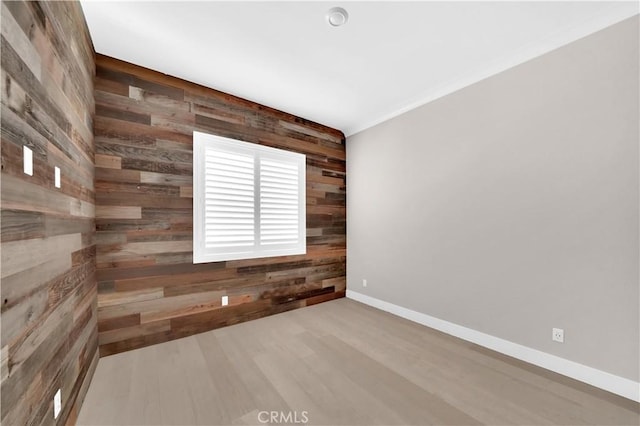 unfurnished room with wooden walls and hardwood / wood-style floors