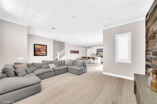 living room with ornamental molding and light hardwood / wood-style flooring