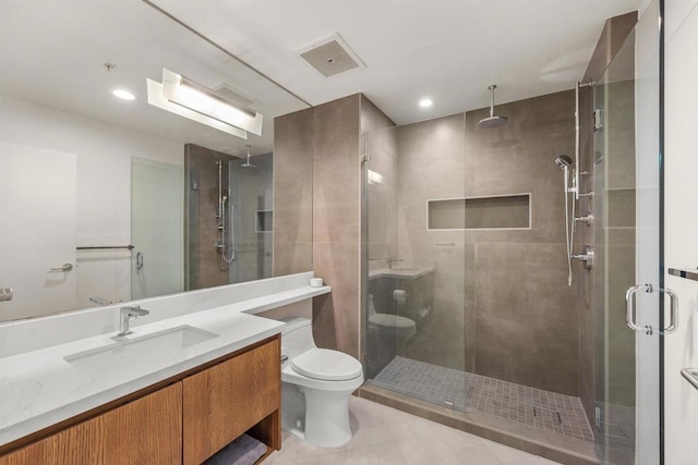 bathroom featuring vanity, tile patterned floors, a shower with door, and toilet