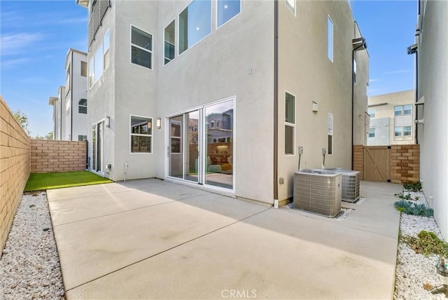 back of house with central air condition unit, a patio area, a fenced backyard, and stucco siding