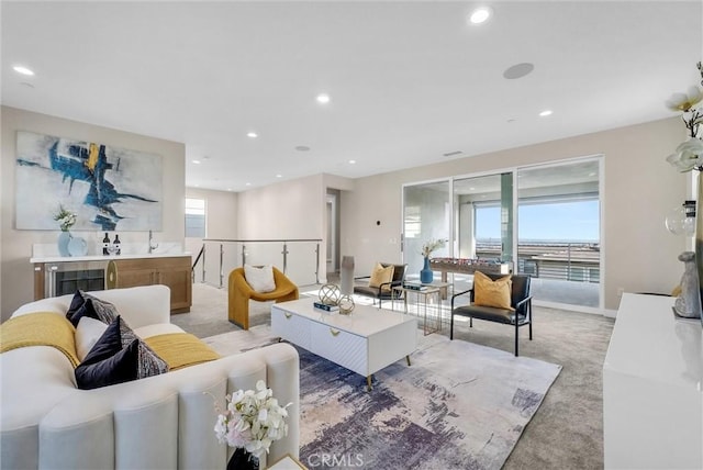 living room with recessed lighting, light colored carpet, and baseboards