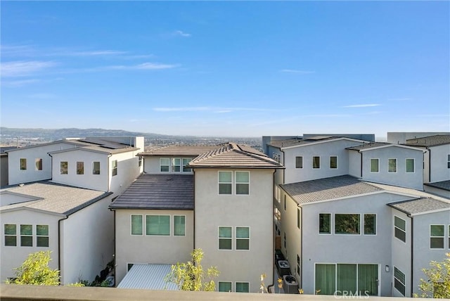 view of front of house with central air condition unit, a residential view, and stucco siding