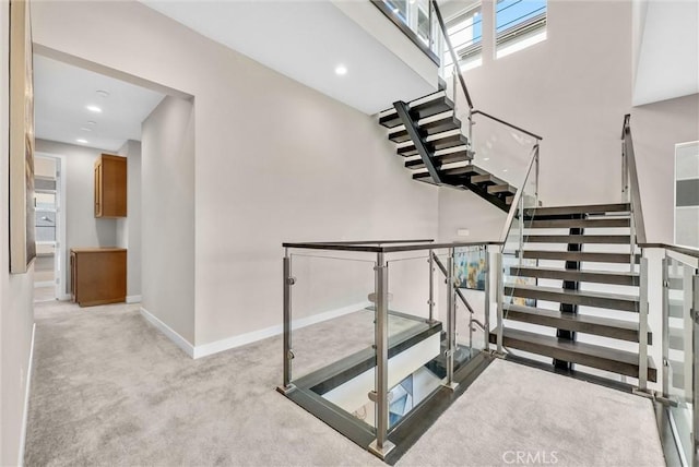 staircase featuring recessed lighting, carpet flooring, a high ceiling, and baseboards