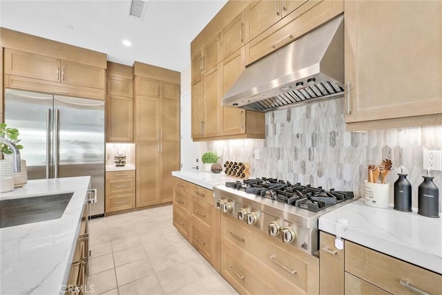 kitchen featuring light stone counters, under cabinet range hood, visible vents, appliances with stainless steel finishes, and backsplash