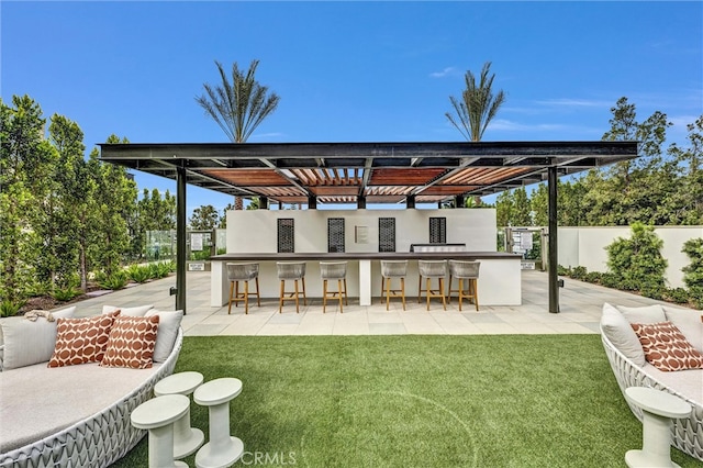 rear view of house featuring a yard, a patio, an outdoor bar, and fence