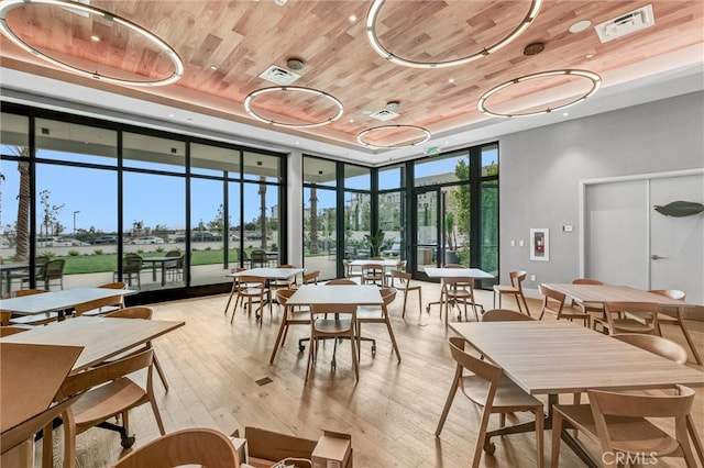 sunroom featuring a tray ceiling, wooden ceiling, and visible vents