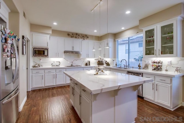 kitchen with hanging light fixtures, white cabinetry, appliances with stainless steel finishes, and a center island