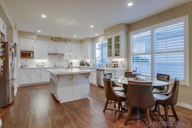 kitchen with a kitchen island, dark hardwood / wood-style floors, white cabinets, and appliances with stainless steel finishes