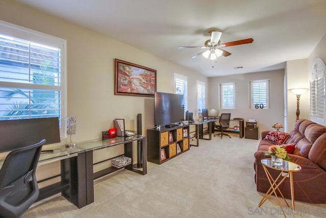 office space with light carpet and ceiling fan