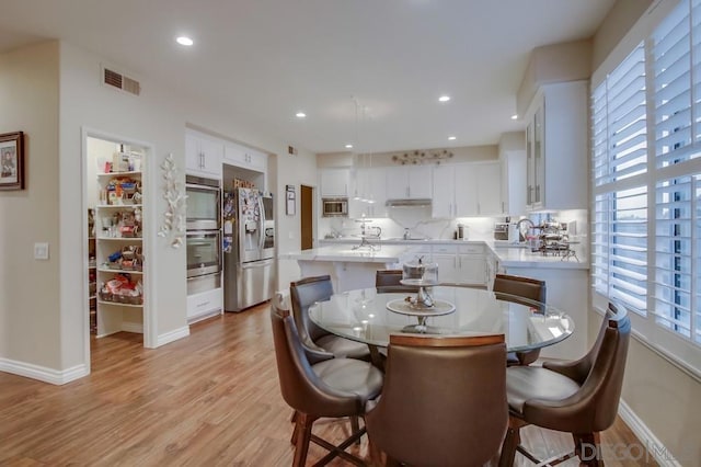 dining area featuring plenty of natural light and light hardwood / wood-style floors