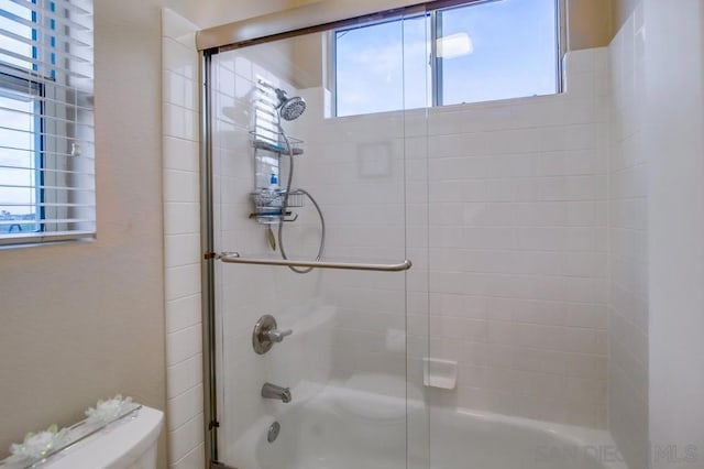 bathroom featuring shower / bath combination with glass door and toilet