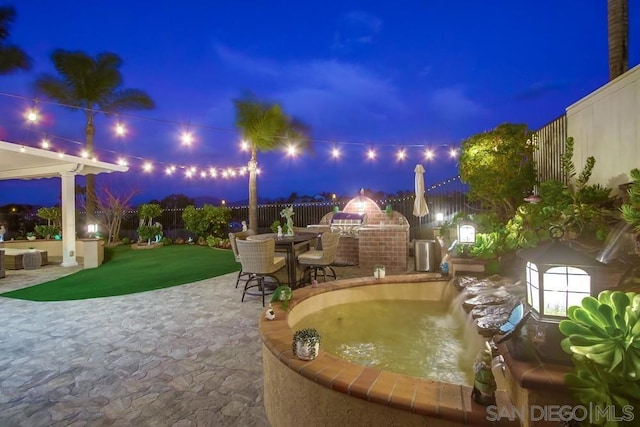 patio at twilight featuring area for grilling and a lawn