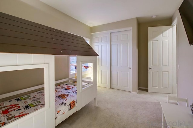 bedroom with light carpet and a closet